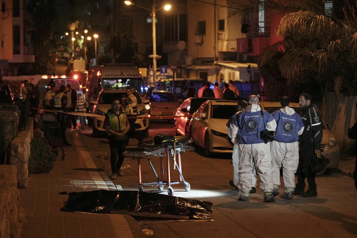 Israeli police work near the covered body of a shooting victim in Bnei Brak, Israel, Tuesday, March 29, 2022. The circumstance of the deadly incident in the city east of Tel Aviv were not immediately clear.