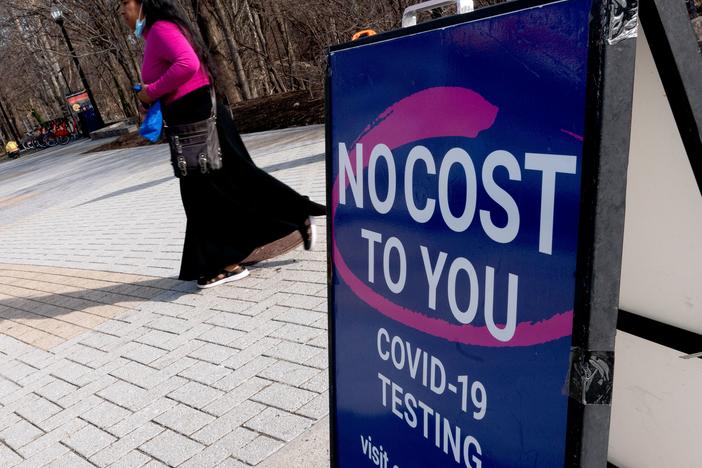 A person walks past a COVID-19 testing location in Arlington, Va., on March 16. A new website launched by the Biden administration will provide a locater for test-and-treat facilities, among other services.