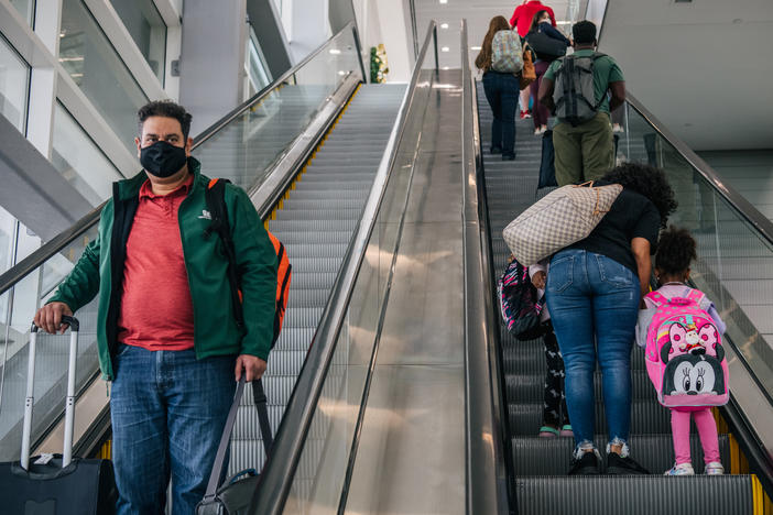 People travel through the George Bush Intercontinental Airport in Houston. Governors from 21 states are suing to end the federal mask mandate for public transportation.