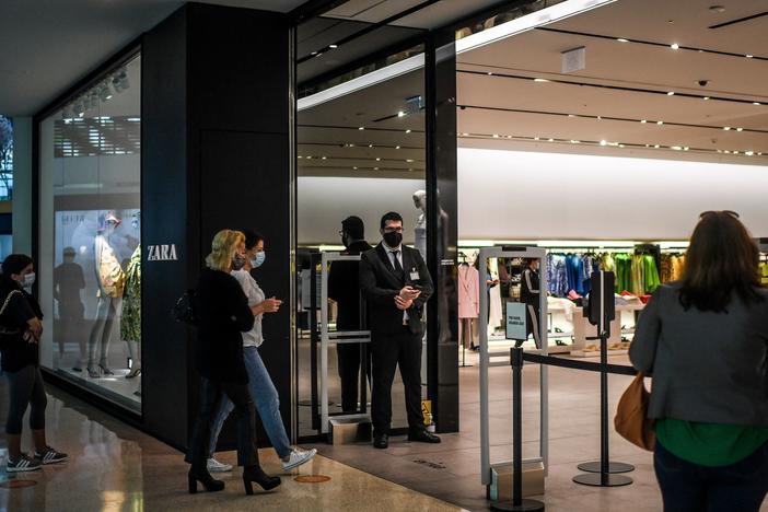 Customers queue to enter a re-opened Zara clothes shop at Colombo shopping center in Lisbon, Portugal, on in April 2021.