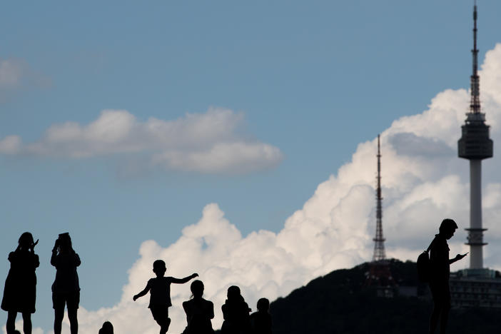 The silhouettes of people are seen as they stand outside the War Memorial of Korea museum in Seoul, South Korea, on Friday, Aug. 11, 2017.