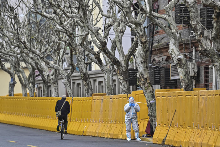 A worker in protective gear stands by barriers set up as part of lockdown measures against COVID-19 in Jing'an district, in Shanghai on March 31.