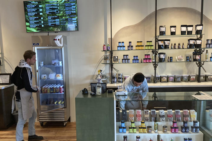 Marijuana dispensary manager LeRoy Roybal, right, and bud tender Benjamin Oliver prepare on Tuesday, March 29, 2022, for the opening of New Mexico's regulated market for recreational cannabis at a Minerva Canna store in Santa Fe, N.M.