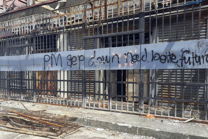 Graffiti written on the burnt out buildings from riots in Honiara's Chinatown from Nov. 2021, is seen in the Solomon Islands on March 30, 2022.