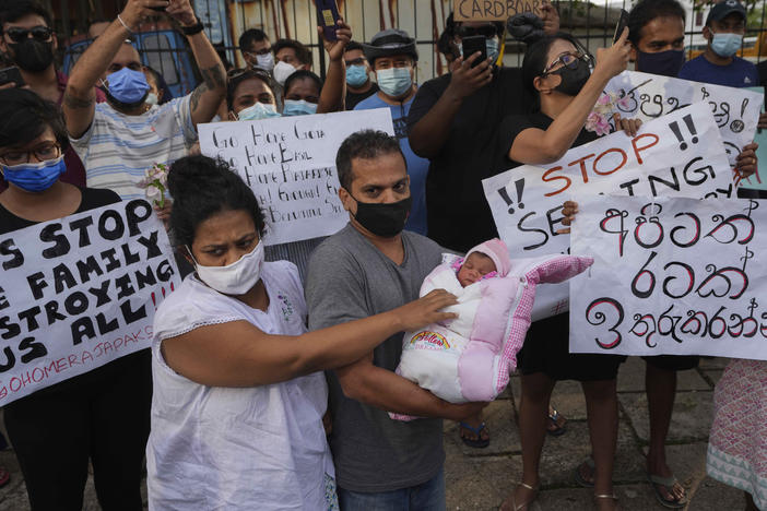 A Sri Lankan couple with their infant join an anti government protest during a curfew in Colombo, Sri Lanka, on Sunday.