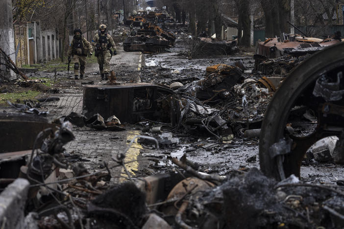 Soldiers walk amid destroyed Russian tanks in Bucha, in the outskirts of Kyiv, Ukraine, on Sunday.