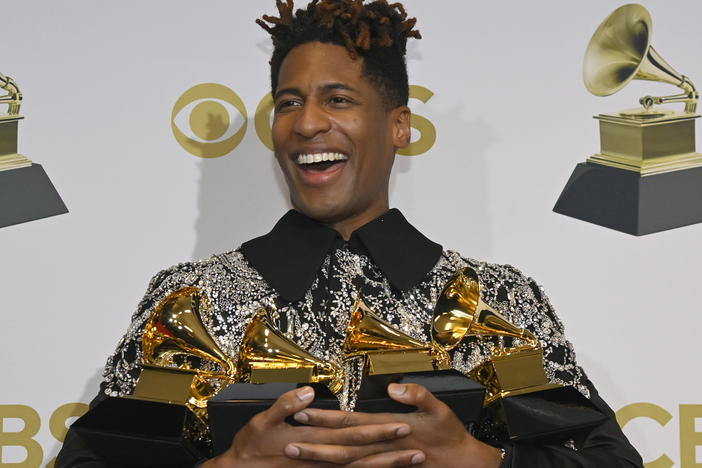 Jon Batiste poses with four of his five trophies during the 64th annual Grammy Awards.