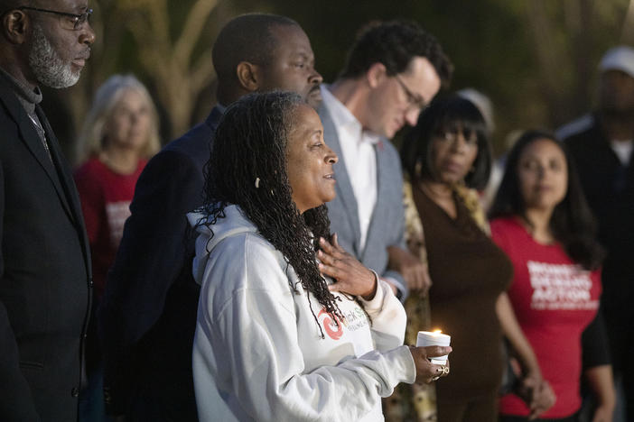 People attend a candlelight vigil to mourn for the death of mass shooting victims at a park on Sunday in Sacramento, Calif.
