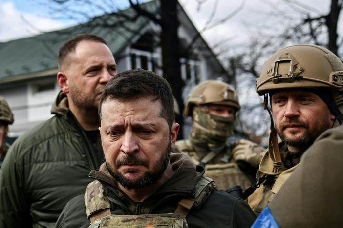 Ukainian President Volodymyr Zelenskyy, center, speaks to the press in the town of Bucha on the northwest edge of the Ukrainian capital Kyiv on Monday.