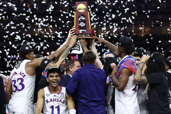 Remy Martin reacts as Kansas Jayhawks players and coaches hold up the National Championship trophy after defeating the North Carolina Tar Heels in the 2022 NCAA Men's Basketball Tournament National Championship on Monday in New Orleans.