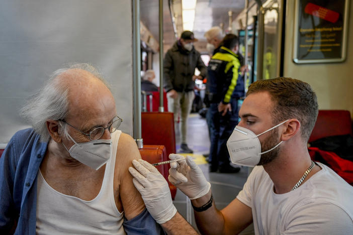 An 85-year-old man receives a booster vaccination in the so-called "vaccination express" tram in central Frankfurt, on Nov. 4, 2021.