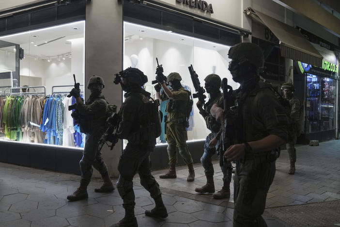 Israeli security forces search for assailants near the scene of a shooting attack in Tel Aviv, on Thursday.