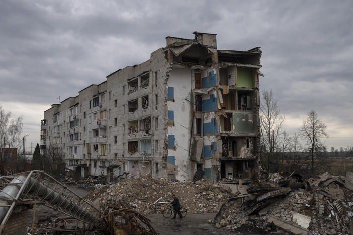 A man with a bicycle walks in front of a destroyed apartment building in the town of Borodyanka, Ukraine, on Saturday, April 9, 2022.