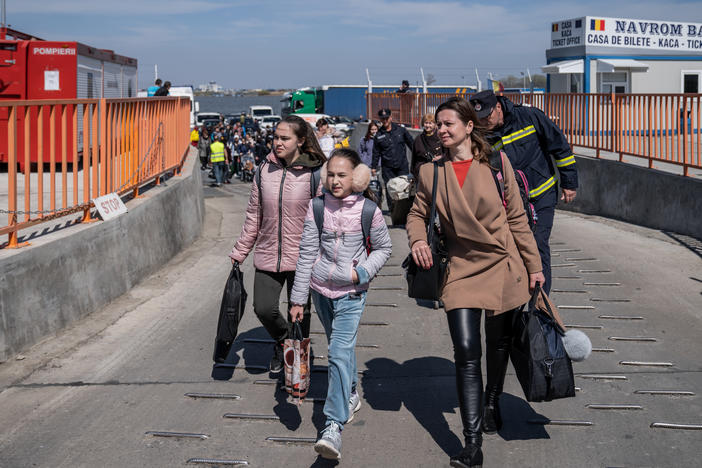 Ukrainian refugees get off the ferry after crossing the Danube into Romania in Isaccea on Friday.