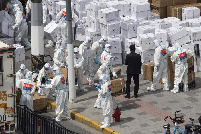 Workers unload supplies including boxes of masks in Shanghai on Sunday, April 10, 2022.