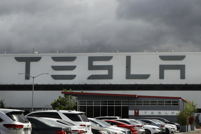 Vehicles are parked outside the Tesla plant in Fremont, Calif., on May 12, 2020. A federal judge has slashed the award to a Black former contract worker over claims that he was subjected to racial discrimination at the factory.