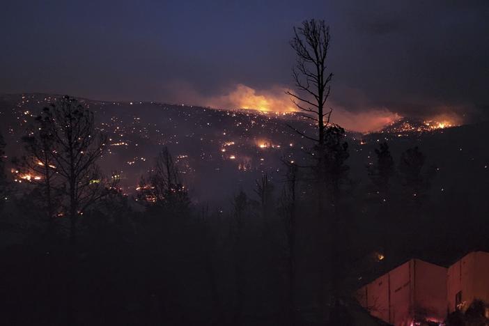 A fire burns along a hillside in Ruidoso, N.M., on Wednesday. Officials say a wildfire has burned about 150 structures, including homes, in Ruidoso.
