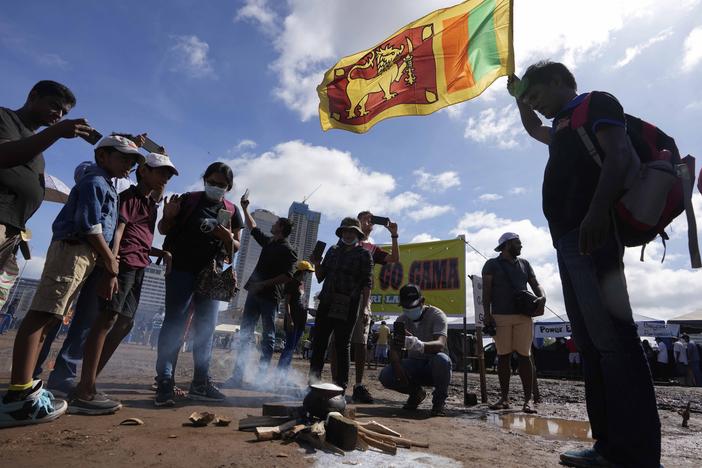 Sri Lankans boil a pot of milk as customary to welcome the dawn of Sinhalese and Tamil new year at a protest site near the president's office in Colombo, Sri Lanka, Thursday, April 14, 2022.