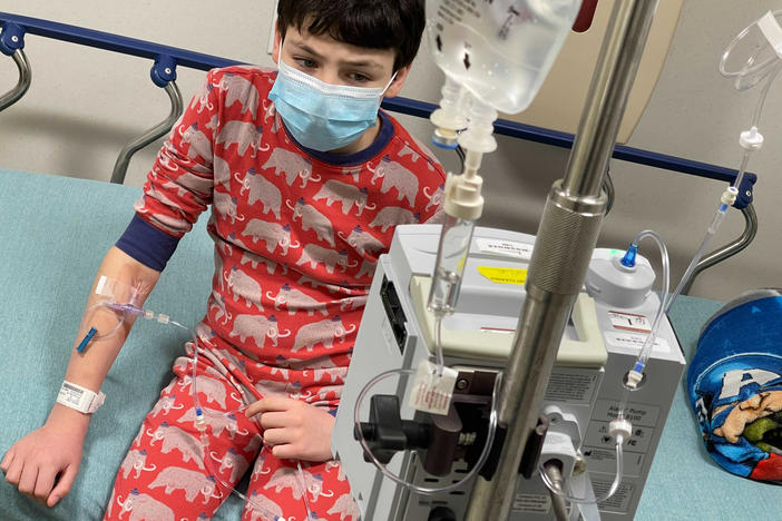 A case of COVID-19 brought 12-year-old Harry Nelson to the emergency room in Syracuse, N.Y., where cases are surging, His mother, photographer Paula Nelson, says he first had mild symptoms — just a headache — but later ran a high fever and began vomiting, which meant he couldn't keep down fever-relief meds. At the ER, he needed saline to rehydrate, Tylenol for his fever and meds to stop vomiting.