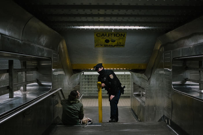 Officer Alexander Bires of SEPTA, the transit system for the Philadelphia region, speaks with a homeless man about outreach services at the 11th Street stop on the Market-Frankford Line in Philadelphia.