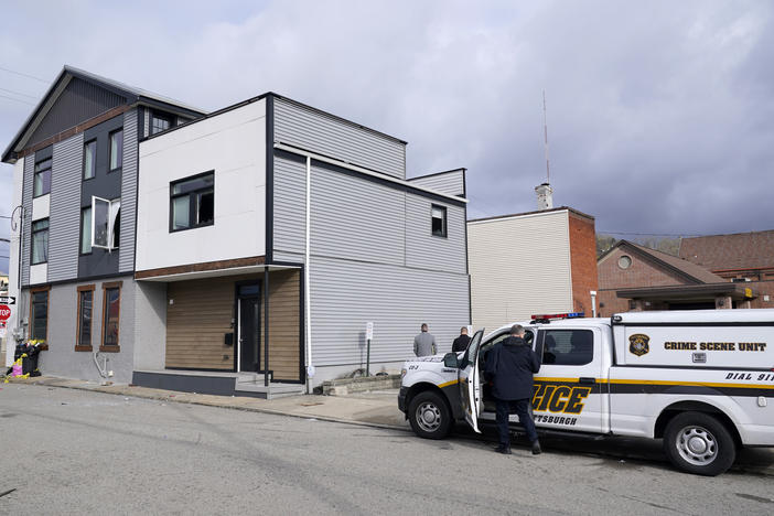 A Pittsburgh Police crime scene unit works the area outside a short-term rental property where a shooting took place early Sunday morning. At least two people were killed.