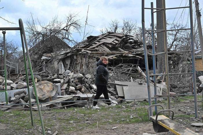 A woman walks past a destroyed house following bombardment in the Ukrainian town of Borodianka, in the Kyiv region, on Sunday.