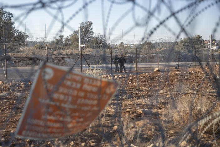 Israeli army soldiers guard a section of Israel's separation barrier last year in the West Bank village of Nilin, west of Ramallah. Two Palestinian men were critically injured by Israeli forces in the occupied West Bank on Monday, the Palestinian Health Ministry said, the latest incident in a wave of Israeli-Palestinian violence during the Muslim holy month of Ramadan.