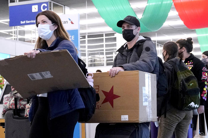 Travelers line up wearing protective masks indoors at O'Hare International Airport in Chicago in December 2021. U.S. District Judge Kathryn Kimball Mizelle voided the national travel mask mandate on Monday.