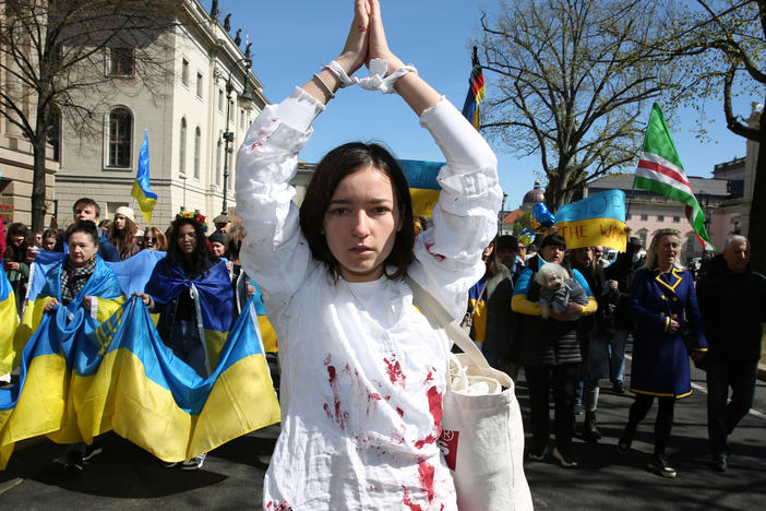 A woman representing a rape victim leads protesters in Berlin demonstrating in an April 16 march against Russian military aggression in the ongoing wars in Ukraine and Syria.