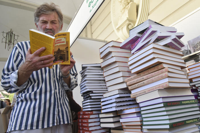 A visitor reads a book at a book fair during a Publishers Forum in Lviv, Ukraine, Wednesday, Sept. 19, 2018. A regional council in western Ukraine had passed a motion to ban all Russian-language books, films and songs in the region.