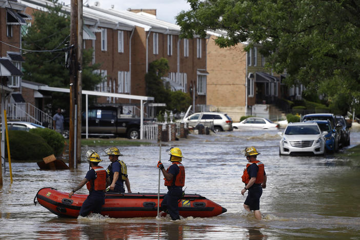 Philadelphia firefighters walk through a flooded neighborhood on Aug. 4, 2020, after Tropical Storm Isaias moved through.