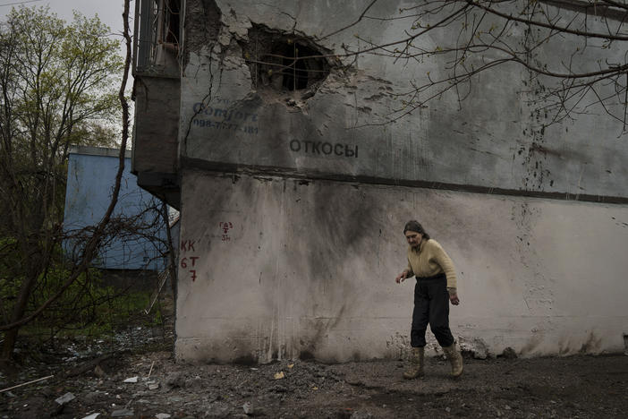 A woman walks next to a damaged building after a Russian bombardment in Kharkiv, Ukraine, on Tuesday. Russia ratcheted up its battle for control of Ukraine's eastern industrial heartland on Tuesday, intensifying assaults on cities and towns along a front hundreds of miles long in what officials on both sides described as a new phase of the war.