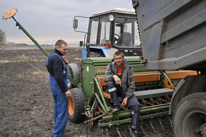 Two farmers take a break from sowing their field with oat, east of Kyiv on April 16.