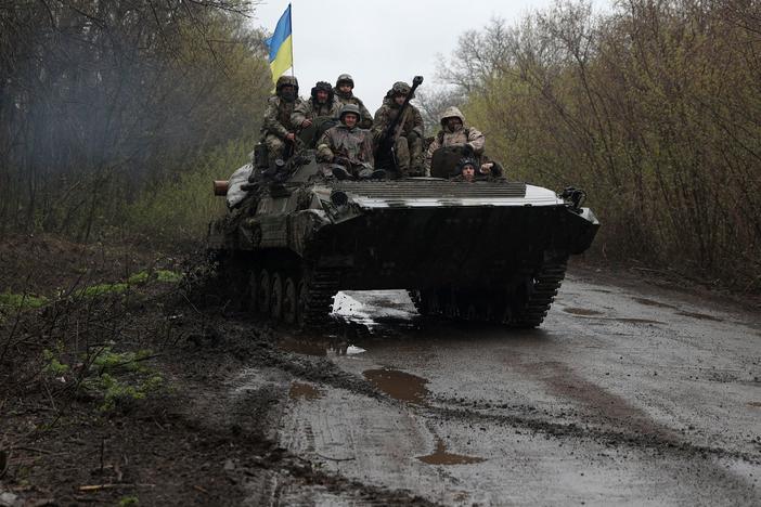 Ukrainian soldiers stand on an armored personnel carrier not far from the front line with Russian troops in Izyum district, Kharkiv region, on Monday.