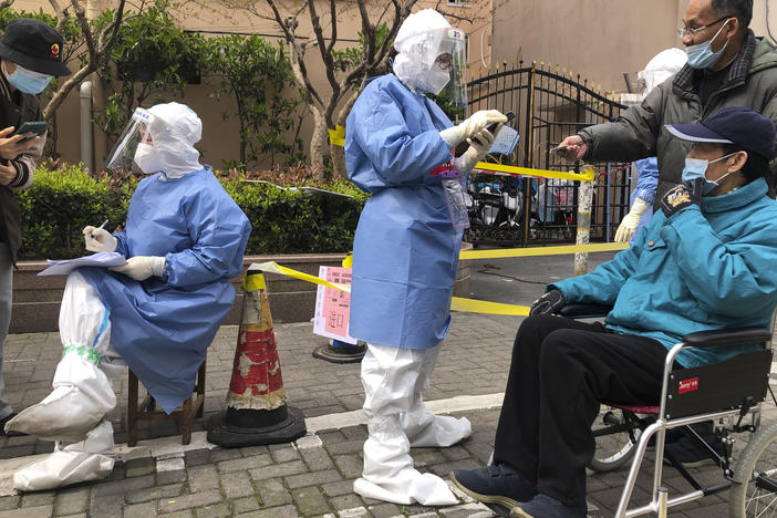 Workers in protective gear register residents for COVID-19 testing in the Jingan district of western Shanghai, China, on April 1, 2022. Shanghai allowed 4 million more people out of their homes Wednesday as coronavirus rules that shut down China's largest city eased and some factories resumed operation.