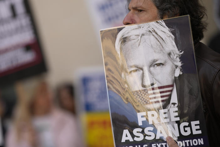 Wikileaks founder Julian Assange supporters hold placards as they gather outside Westminster Magistrates court in London on Wednesday.