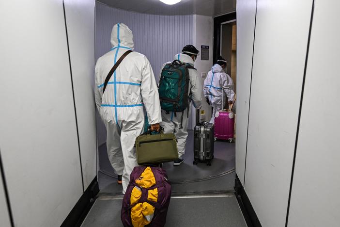 Masks are just one protective measure for these airline passengers arriving in Shanghai from Paris.