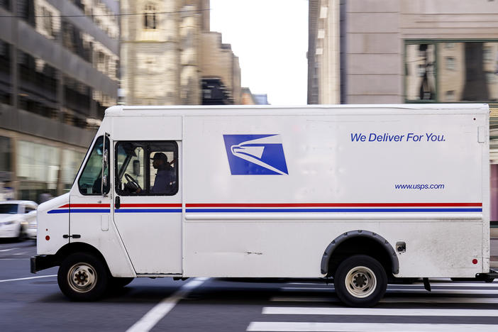 A U.S. Postal Service truck drives in Philadelphia. The service is about to set longer delivery standards for first-class packages, in a move that its regulator says will not have a big effect on its finances.