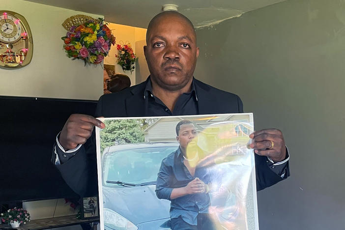 Peter Lyoya holds up a picture of his son Patrick Lyoya, 26, in his home in Lansing, Mich., on April 14. Patrick was facedown on the ground when he was fatally shot in the head by a Grand Rapids police officer this month.