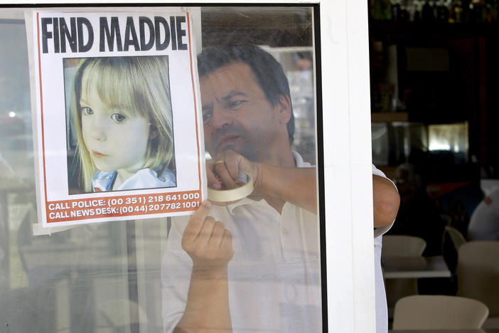 A waiter hangs a picture of missing 3-year-old girl Madeleine McCann on a restaurant's window on May 10 2007, in Praia da Luz, southern Portugal.