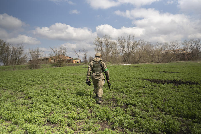 Capt. Daniil, a public affairs officer in the Ukrainian military, walks through a field in Mala Rohan, on the outskirts of Ukraine's northeastern city of Kharkiv. He is recording the aftermath of fighting between occupying Russian soldiers and Ukrainian forces.