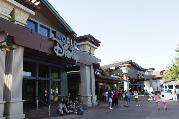 Disney operates like its own county government in Florida — but that could change, now that Gov. Ron DeSantis has signed a new bill lawmakers approved this week. Here, tourists walk through Disney Springs at Walt Disney World in Orlando, Fla., last month.