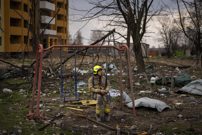 A firefighter sits on a swing next to a building destroyed by a Russian bomb in Chernihiv on Friday.