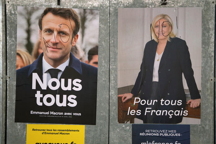 Presidential campaign posters of French President and centrist candidate for reelection Emmanuel Macron, left, and French far-right presidential candidate Marine Le Pen, in Salies de Bearn, southwestern France, Saturday, April 23, 2022.