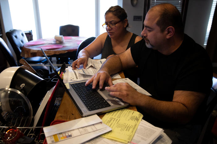 Claudia and Jesús Fierro of Yuma, Ariz., review their medical bills. They pay $1,000 a month for health insurance yet still owed more than $7,000 after two episodes of care at the local hospital.