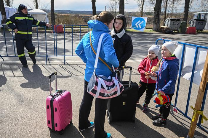 A Ukrainian refugee speaks with a local interpreter as she and her two children arrive at the Siret border crossing between Romania and Ukraine on April 18.