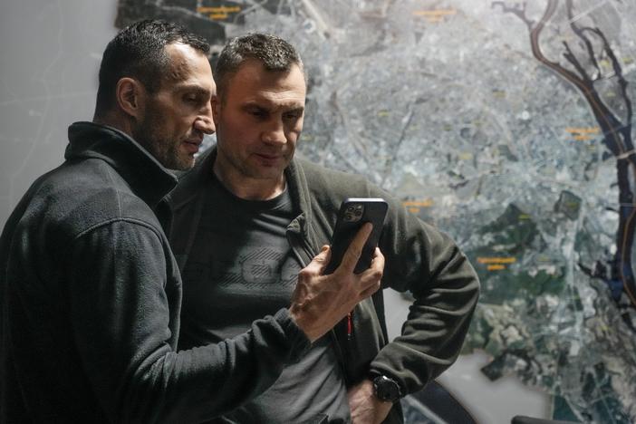 Kyiv Mayor Vitali Klitschko (right) and his brother Wladimir Klitschko check a phone at city hall on Feb. 27. When Russia invaded Ukraine, many expected Moscow to knock out the Ukrainian communications network. But Ukrainian systems, for both civilians and the military, continue to function. Ukraine, meanwhile, has regularly intercepted Russian military communications.