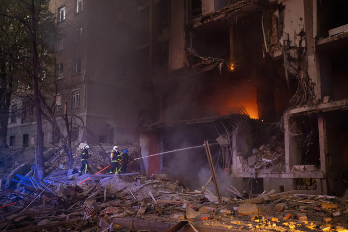 Firefighters try to put out a fire following an explosion in Kyiv on Thursday, the same day of a visit by the head of the United Nations.