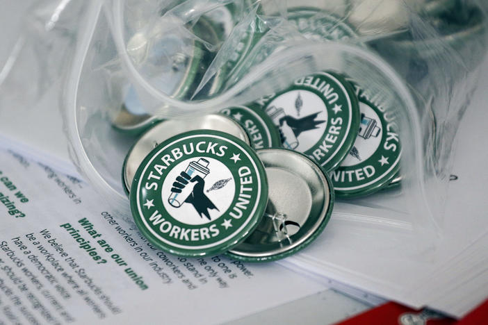 Pro-union pins sit on a table during a watch party for Starbucks' employees union election, Dec. 9, 2021, in Buffalo, N.Y. The top lawyer for the National Labor Relations Board said Thursday, April 7, she will ask the board to rule that mandatory meetings some companies hold to persuade their workers reject unions is in violation of federal labor law.