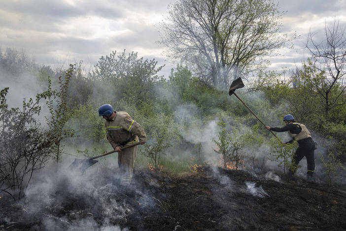 Rescue servicemen extinguish a bush fire after shelling in Mykolaivka, Donetsk region, eastern Ukraine, on Friday.